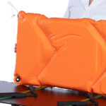 Woman holding an Orange Orfit Vacuum Bag over a couchtop with two indexing bars.